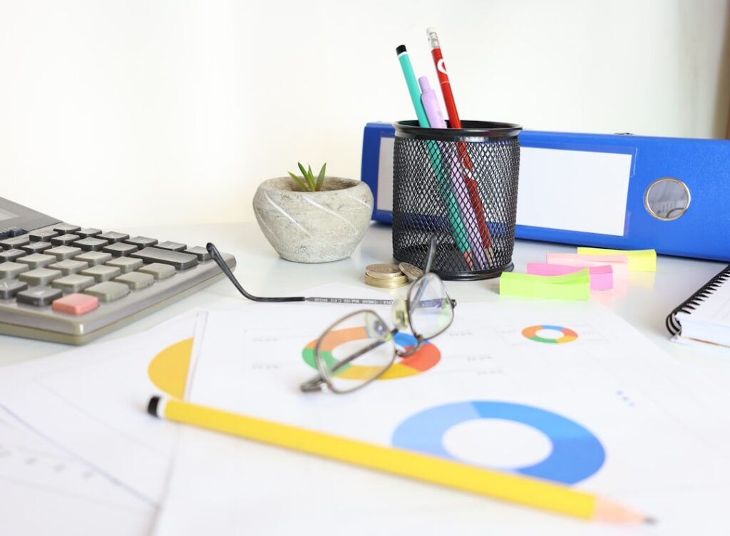 bookkeeping vs accounting modern office desk financial charts ledger